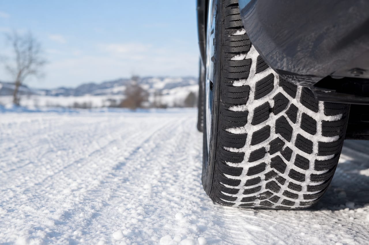 Winterreifen mit Profil auf verschneiter Fahrbahn